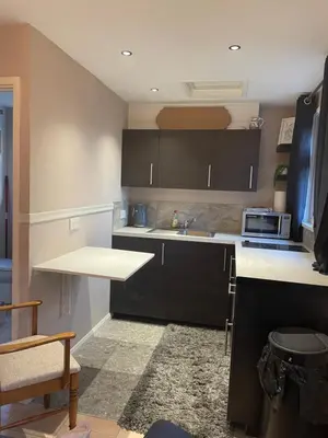 a kitchen with black cabinets and a white counter top at Be Our Guest in Earls Colne