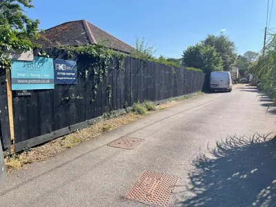 a van driving down a road next to a fence at Be Our Guest in Earls Colne