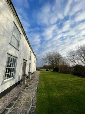 a building with a grass yard next to a building at Grade 1 Listed Farm House 14 ppl 45 mins London in Fyfield