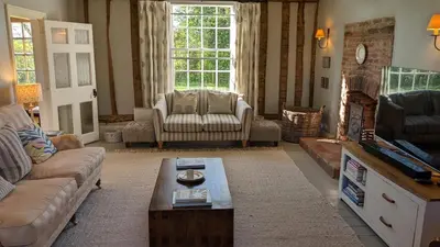 a living room with a couch and a table at Grade 1 Listed Farm House 14 ppl 45 mins London in Fyfield