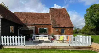 a house with a white picket fence at Grade 1 Listed Farm House 14 ppl 45 mins London in Fyfield
