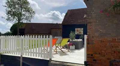 a white picket fence in a backyard with a table and chairs at Grade 1 Listed Farm House 14 ppl 45 mins London in Fyfield