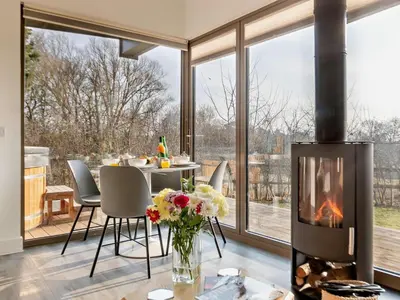 a living room with a fireplace and a table with flowers at 2 Bed in Colchester oc-95941 in East Bergholt