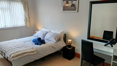 a bedroom with a bed with a blue stuffed animal on it at Ipswich Town 3 Bed House in Copdock
