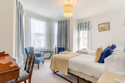 a bedroom with a bed and a desk and windows at 4 Bed in Harwich oc-s30791 in Harwich