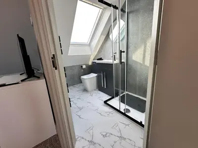 a bathroom with a glass shower and a toilet at Captivating 7 -Bed House in Waltham Abbey in Waltham Abbey