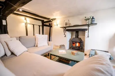 a living room with a couch and a fireplace at Wayside Cottage, Dennington in Brundish