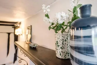 a blue and white vase with flowers on a table at Wayside Cottage, Dennington in Brundish