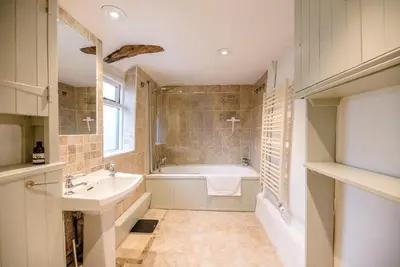 a bathroom with a bath tub and a sink at Wayside Cottage, Dennington in Brundish