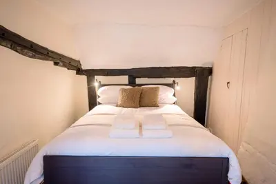 a bedroom with a bed with two towels on it at Wayside Cottage, Dennington in Brundish
