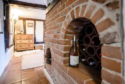 a wine bottle on a brick wall in a room at Wayside Cottage, Dennington in Brundish