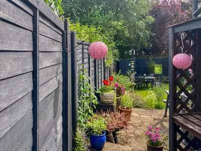 a garden with potted plants and a fence at Sunny Meadow Cottage in Sudbury