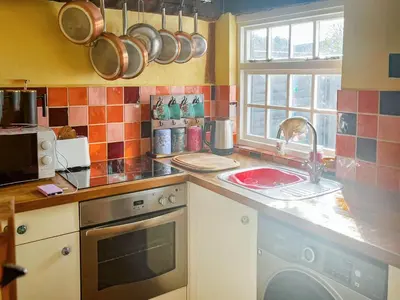 a kitchen with a sink and a stove top oven at Sunny Meadow Cottage in Sudbury