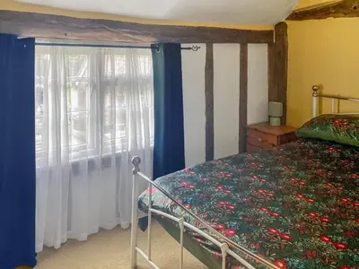 a bedroom with a bed and a window at Sunny Meadow Cottage in Sudbury