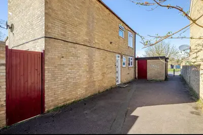 a brick building with a red door and a garage at Nice and spacious room in Chesterton