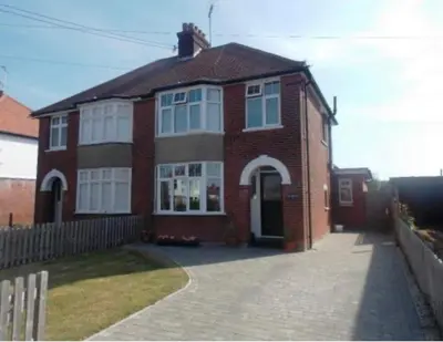 a brick house with a driveway in front of it at Cosy room in Faulkbourne