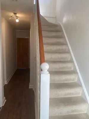 a staircase in a home with a white stair case at Cosy room in Faulkbourne