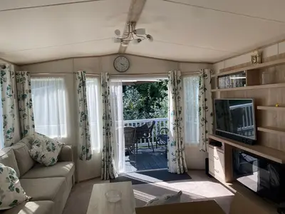 a living room with a couch and a television at 2 Bed Static Caravan sleeps 6 Saxmunham in Saxmundham