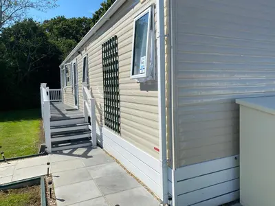 a side of a house with a porch and stairs at 2 Bed Static Caravan sleeps 6 Saxmunham in Saxmundham