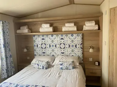 a bedroom with a bed with pillows and towels at 2 Bed Static Caravan sleeps 6 Saxmunham in Saxmundham