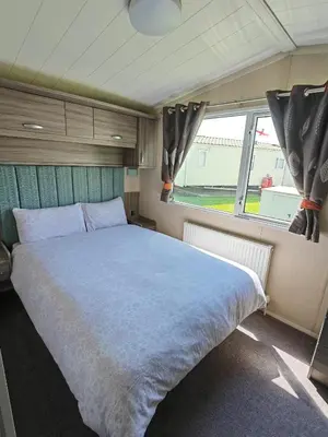 a bedroom with a large bed and a window at Green House Moselle in Jaywick Sands
