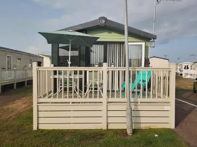a gazebo with a table and an umbrella at Green House Moselle in Jaywick Sands