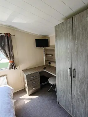 a bedroom with a desk with a tv and a bed at Green House Moselle in Jaywick Sands