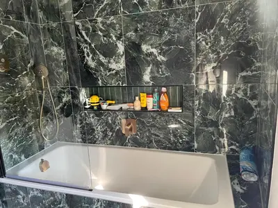 a bath tub in a bathroom with a black marble wall at Charming Home in Central Cambridge in Cambridge
