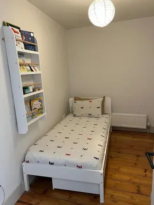 a small bedroom with a bed and a shelf at Charming Home in Central Cambridge in Cambridge