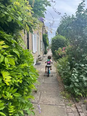 a little boy riding a bike down a street at Charming Home in Central Cambridge in Cambridge