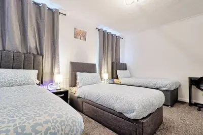 a bedroom with two beds and a window at Spacious 4 Bedroom Home - Sleeps Up to 9 Guests in Chelmsford