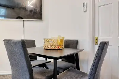a table with chairs and a basket of food on it at Spacious 4 Bedroom Home - Sleeps Up to 9 Guests in Chelmsford