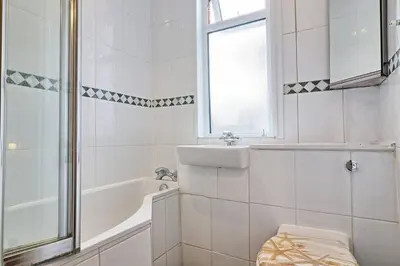 a white bathroom with a tub and a sink at Spacious 4 Bedroom Home - Sleeps Up to 9 Guests in Chelmsford