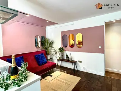 a living room with a red couch and mirrors at R&O Property Experts 2 BR Super Central Cambridge in Cambridge
