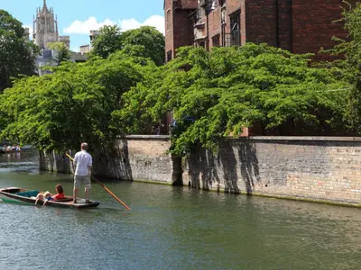 a man is rowing a boat on a river at R&O Property Experts 2 BR Super Central Cambridge in Cambridge