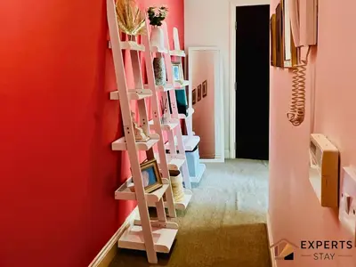 a room with shelves in a room with a red wall at R&O Property Experts 2 BR Super Central Cambridge in Cambridge