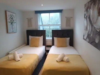 two twin beds in a room with a window at R&O Property Experts 2 BR Super Central Cambridge in Cambridge