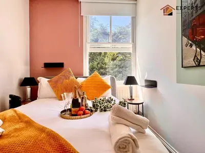a bed with a bowl of fruit on it with a window at R&O Property Experts 2 BR Super Central Cambridge in Cambridge