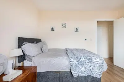 a white bedroom with a bed and a desk at Comfy city room in Cambridge