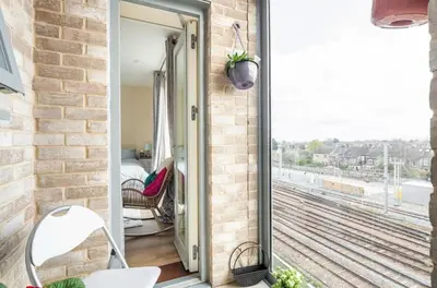 a room with a balcony with a view of the tracks at Comfy city room in Cambridge