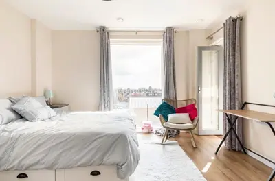 a bedroom with a bed and a desk and a window at Comfy city room in Cambridge
