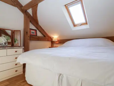 a bedroom with a white bed and a window at Woodland Retreat Lodge in Woodbridge