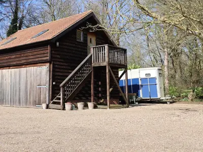 a large wooden barn with a ramp leading to a garage at Woodland Retreat Lodge in Woodbridge
