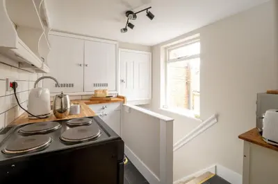 a kitchen with a black stove top oven at The Nest, Aldeburgh - Prime location close to the beach and town amenities - Aldeburgh Coastal Cottages in Aldeburgh