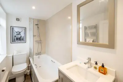 a bathroom with a sink and a toilet and a mirror at The Nest, Aldeburgh - Prime location close to the beach and town amenities - Aldeburgh Coastal Cottages in Aldeburgh
