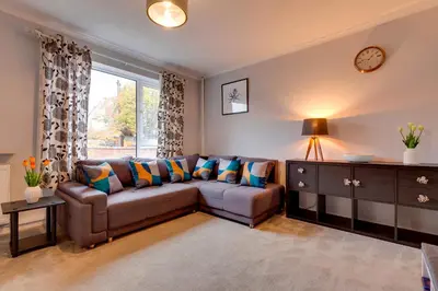 a living room with a couch and a window at Pass the Keys Spacious and modern house with Free Parking in Cambridge