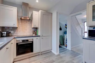 a kitchen with white cabinets and a stove at Pass the Keys Spacious and modern house with Free Parking in Cambridge