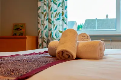 a roll of toilet paper sitting on top of a bed at Pass the Keys Spacious and modern house with Free Parking in Cambridge