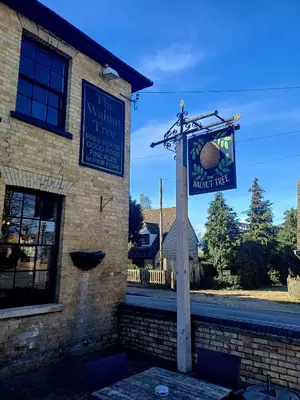 a sign for a restaurant on the side of a building at the walnut tree in Worlington
