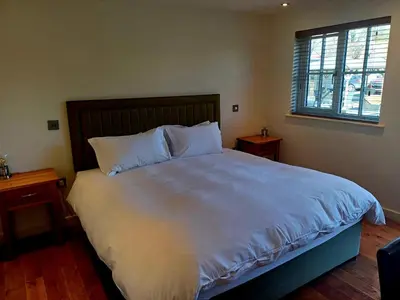 a bedroom with a large bed with white sheets and pillows at the walnut tree in Worlington